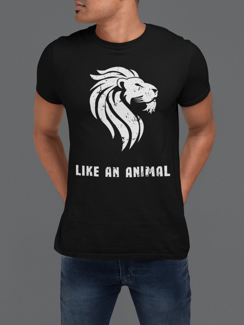 K&ouml;nnte beinhalten: Schwarzes T-Shirt mit einem wei&szlig;en L&ouml;wen-Motiv und dem Aufdruck "LIKE AN ANIMAL" auf der Vorderseite.