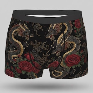 Puede incluir: Calzoncillos bóxer negros con un estampado repetido de dragones y rosas rojas. Los dragones tienen detalles dorados y rojos, sobre un fondo negro. La cintura es de color negro liso.