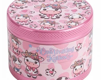 May include: A cylindrical pink metal storage tin featuring a repeating pattern of cartoon cows wearing flower crowns and bows. The side of the container displays the text Cowtivating Kuties in a light blue script font against a pink cow print background.