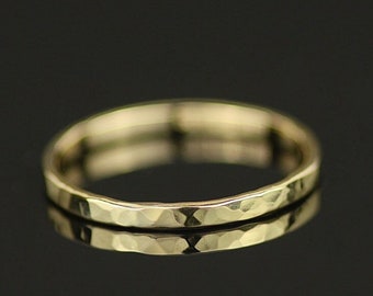May include: A simple gold band ring with a hammered texture.