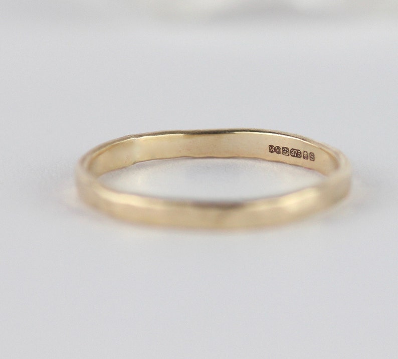 K&ouml;nnte beinhalten: Ein d&uuml;nner Goldring mit einer Punze auf der Innenseite des Rings. Die Punze lautet "9ct 375 99".