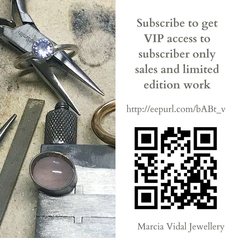 May include: A close-up of a silver ring with a light purple gemstone. The ring is being held by a pair of pliers on a workbench. The image also includes a QR code and text that reads "Subscribe to get VIP access to subscriber only sales and limited edition work http://eepurl.com/bABt_v Marcia Vidal Jewellery".