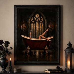 Op de afbeelding: Een ingelijste kunstdruk met een donkerrood bad op pootjes in een gotische kamer met boogramen en kandelaars. In het bad zijn benen in zwarte panty's met stippen omhoog gestoken en een hand houdt een glas rode wijn vast.