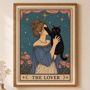 Puede incluir: Impresión enmarcada de una carta del tarot con una mujer con un vestido azul sosteniendo un gato negro. La carta se titula "THE LOVER" y tiene un fondo estrellado con flores rosas y una cortina rosa.