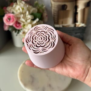 Può includere: Una tazza di ceramica bianca con manico nero e la scritta "But First, Coffee" in grassetto nero. La tazza è piena di un liquido scuro, probabilmente caffè, e poggia su una superficie chiara.
