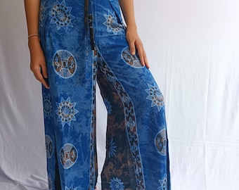 May include: Blue wide-leg trousers with a tie waist and a geometric pattern. The pattern features circles, stars, and other abstract shapes in shades of blue, brown, and white.