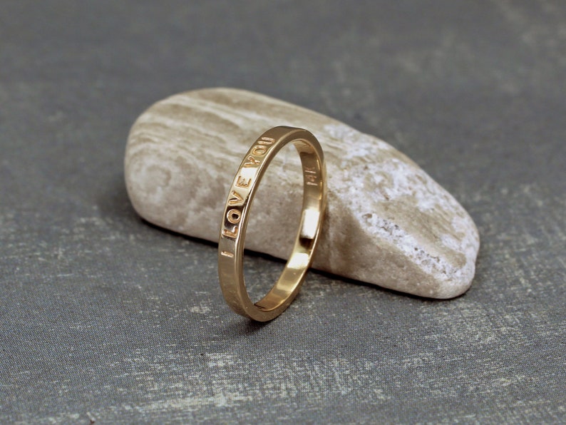 2mm gold ring with custom inscription. The ring has a smooth shiny finish.