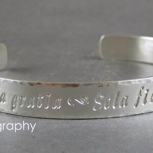 Personalized silver cuff bracelet shown with the Calligraphy letter style.