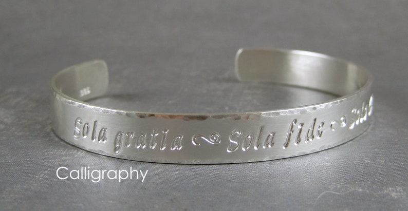 Personalized silver cuff bracelet shown with the Calligraphy letter style.