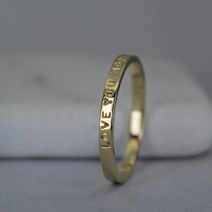 Example of a 2mm wide gold ring with a custom inscription - Love you more.