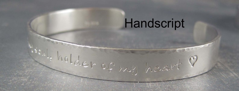 Personalized silver cuff bracelet shown with the Hand script letter style.