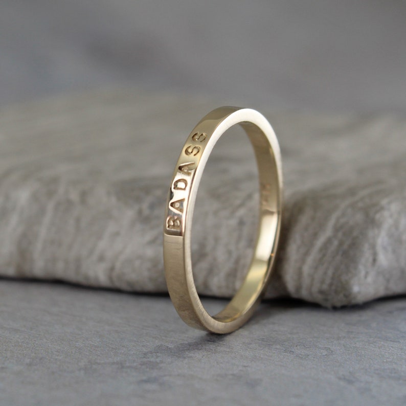 Example of a personalized gold ring. This ring has the inscription Badass.