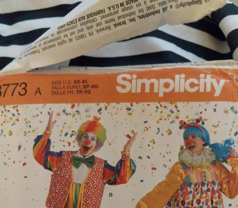 K&ouml;nnte beinhalten: Eine Simplicity Schnittmusterh&uuml;lle 8773 mit zwei Clowns in bunten Kost&uuml;men und Konfetti-Grafiken. Die orangefarbene Kopfzeile zeigt den Markennamen und den Gr&ouml;&szlig;enbereich von XS bis XL. Das Design umfasst eine Weste, eine Fliege und einen R&uuml;schenkragen.
