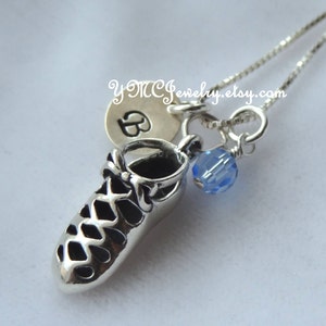 May include: Silver necklace with a charm of a silver Irish dancing shoe, a silver charm with the letter B, and a light blue crystal charm.