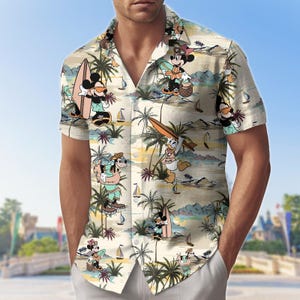 Może przedstawiać: Koszula z krótkim rękawem zapinana na guziki z tropikalnym nadrukiem przedstawiającym postacie z kreskówek, takie jak Myszka Miki, Myszka Minnie, Kaczor Donald i Goofy. Koszula ma beżowe tło z palmami, żaglówkami i sceną na plaży.