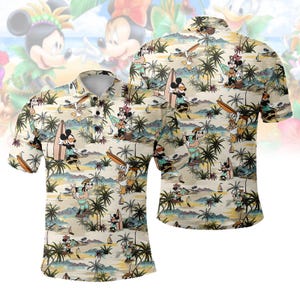 Puede incluir: Un polo beige con un diseño tropical que presenta personajes de dibujos animados surfeando y disfrutando de la playa. El diseño incluye palmeras, veleros y personajes de Disney como Mickey y Minnie Mouse. La camisa tiene cuello y mangas cortas.