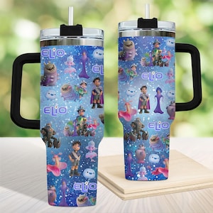 May include: A double-walled tumbler with a black handle and lid, featuring a vibrant blue background. The tumbler is adorned with cartoon characters and the name "ELIO" in white. Includes a straw.