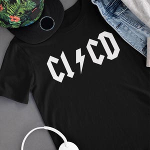 May include: Black t-shirt with a white graphic of the word "C14CD" in a bold, stylised font with a lightning bolt in the middle.