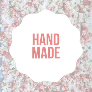 May include: White background with a pink and white floral border. The text "HAND MADE" is written in pink letters on a white background.