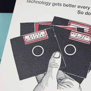 May include: A birthday card with a black and white illustration of floppy disks. The card has the text "Happy Birthday" and "And Many More" on the floppy disks.