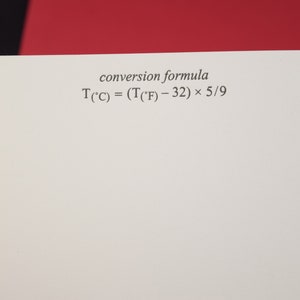 May include: A white sheet of paper with the text "conversion formula" and the formula "T(&deg;C) = (T(&deg;F) - 32) &times; 5/9" written in black ink.
