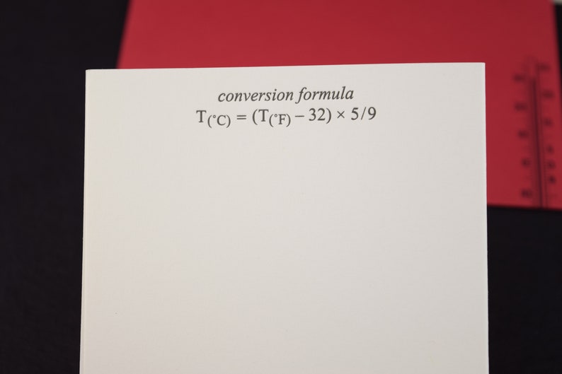 May include: A white sheet of paper with the text "conversion formula" and the formula "T(&deg;C) = (T(&deg;F) - 32) &times; 5/9" written in black ink.