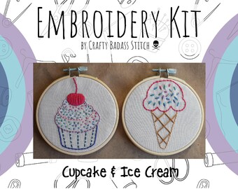 May include: Embroidery kit featuring two designs: a cupcake with a red cherry and sprinkles and an ice cream cone with sprinkles. The designs are embroidered on white fabric and framed in wooden hoops. The kit is titled "Cupcake & Ice Cream" and is by "Crafty Badass Stitch".