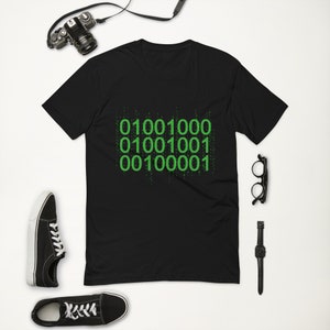 May include: Black t-shirt with a green graphic of binary code. The code reads "01001000 01001001 00100001".