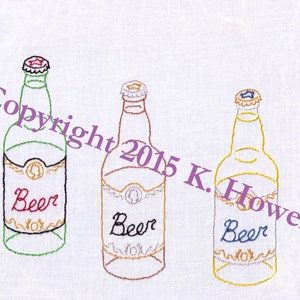 May include: Three embroidered beer bottles with red, brown, and blue bottle caps and labels that say "Beer".