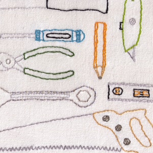 May include: Embroidered design of various tools on a white fabric background. The tools include a wrench, pliers, a pencil, a screwdriver, a saw, a level, and a hammer.