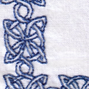 May include: Blue embroidered design on a white fabric background. The design is a repeating pattern of interlocked knots.
