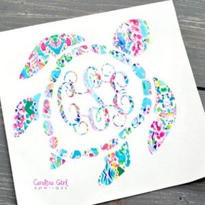 May include: A colorful sea turtle design with a monogram in the center, featuring a vibrant pattern of pink, blue, and green floral and geometric shapes. The text "Carolina Girl Boutique" is at the bottom.