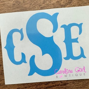 May include: A blue monogram decal with the letters "CSE" in a decorative script font. The decal is on a white background.