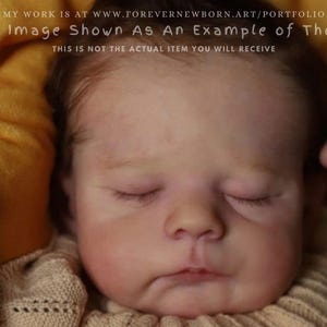 Może przedstawiać: Zbliżenie noworodka z zamkniętymi oczami. Dziecko ma jasną skórę z różowymi policzkami i lekko zmarszczonym czołem. Dziecko ma na sobie beżowy sweter. Obraz zawiera tekst: "This Image Shown As An Example of The Kit."