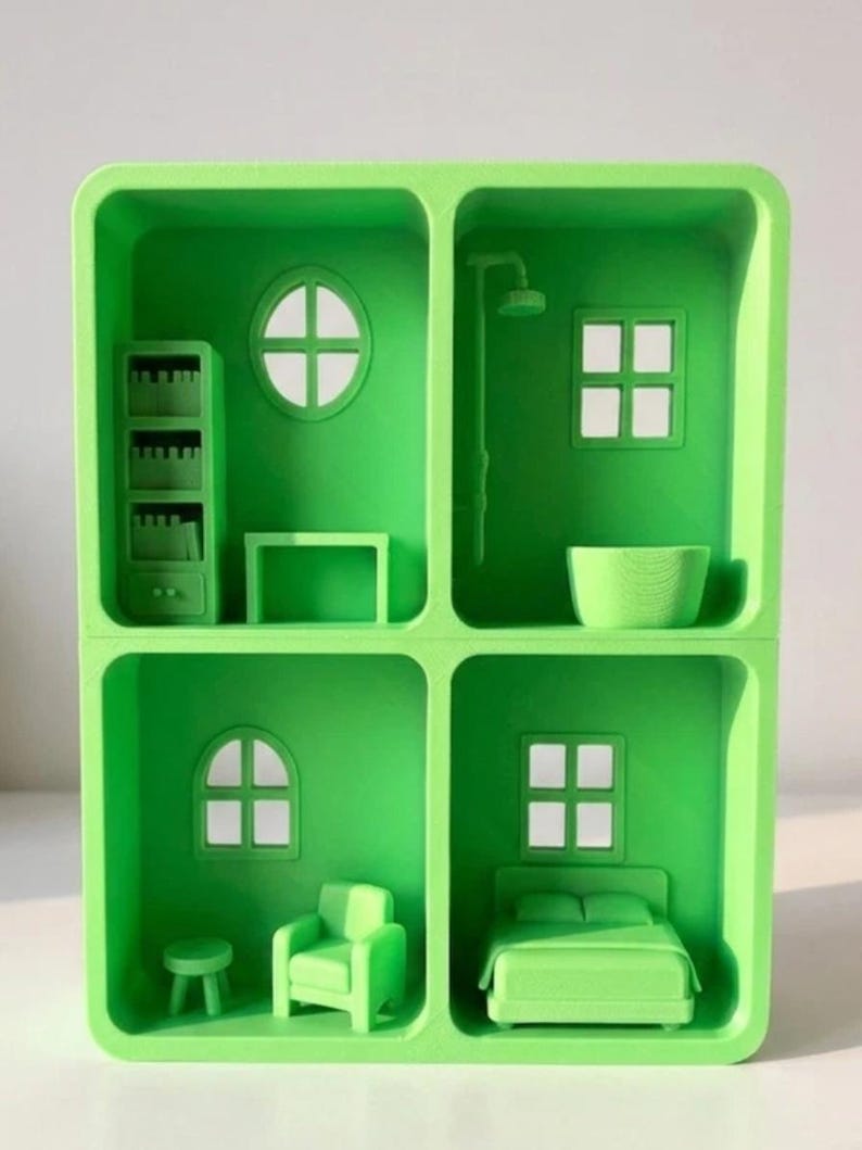 May include: A bright green miniature dollhouse with four distinct rooms. Each room features small-scale furniture, including a bed, armchair, bookshelf, and shower. The windows are square or circular, and the overall design is minimalist and modern.