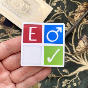 May include: A square sticker with four sections. The top left section is red with a white letter E. The top right section is blue with a white male symbol. The bottom left section is white. The bottom right section is green with a white checkmark.
