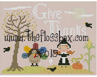 May include: Cross stitch pattern featuring a pilgrim girl, a turkey, and a corn stalk. The pattern includes the text "Give Thanks" and the website address "www.theflossbox.com".