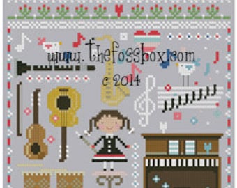 Pode incluir: Um padrão de ponto cruz com uma menina tocando música com uma variedade de instrumentos, incluindo um piano, uma guitarra, tambores e um saxofone. O padrão também inclui notas musicais, pássaros e o texto "MUSIC" e "www.thefossbox.com c 2014".