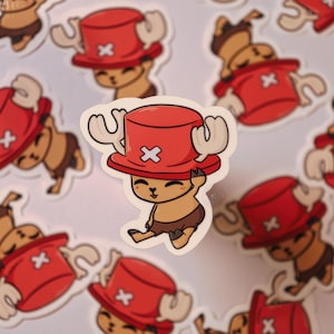 May include: A set of 10 cartoon stickers featuring a red-hatted, brown-furred character with antlers. The character is smiling and has a white 'X' on its hat.