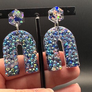 Olśniewające, błyszczące, niebieskie kolczyki z brokatem. #y2kjewelry #galaxyjewelry #statementearrings #aruraearrings