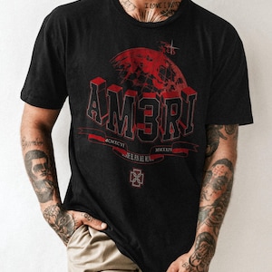 May include: Black t-shirt with a red graphic design featuring the word "AM3RI" in a 3D font, a globe, and the text "DONDE EL FIN DEL MUNDO". The shirt also includes the Roman numerals MCMXCVI and MMXXIV.