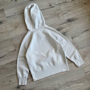 Op de afbeelding: Een lichtgrijs hooded sweatshirt met een zak. De trui is gemaakt van een zachte, comfortabele stof.