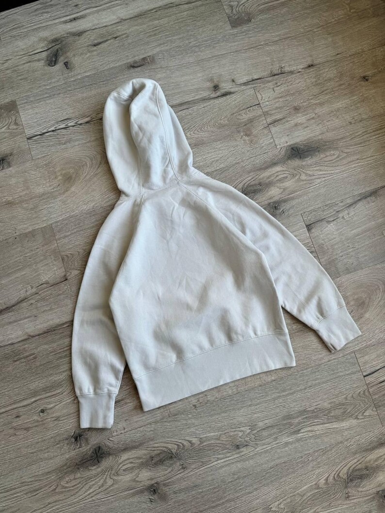 Op de afbeelding: Een lichtgrijs hooded sweatshirt met een zak. De trui is gemaakt van een zachte, comfortabele stof.