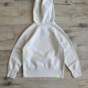 Op de afbeelding: Een lichtbeige hoodie met lange mouwen en een kangoeroezak. De hoodie is gemaakt van een zachte, comfortabele stof.