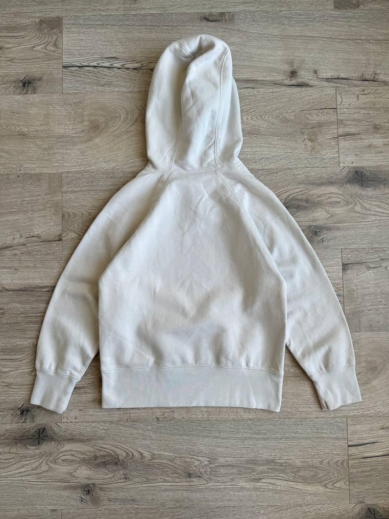 Op de afbeelding: Een lichtbeige hoodie met lange mouwen en een kangoeroezak. De hoodie is gemaakt van een zachte, comfortabele stof.