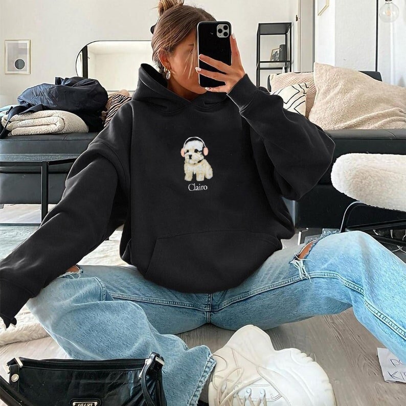 May include: Black hooded sweatshirt featuring a white dog wearing headphones with the word "Clairo" printed on the front.