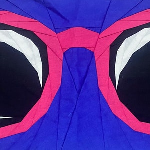 May include: A pair of pink sunglasses with black lenses and white accents. The sunglasses are made of fabric and are folded into a circular shape.