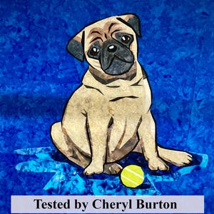 May include: A beige pug dog with black eyes and a black nose sits on a blue background with a yellow tennis ball. The text "Tested by Cheryl Burton" is at the bottom of the image.