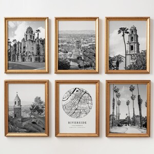 May include: Six framed black and white prints with gold frames. The prints depict architectural landmarks, cityscapes, and a map of Riverside, California. The frames are rectangular and have a textured gold finish. The prints are arranged in a grid.