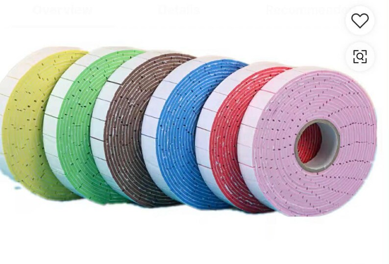 May include: A collection of colorful foam tape rolls. The rolls are in shades of yellow, green, brown, blue, red, and pink. Each roll has a white backing with small black dots. The tape is likely used for crafts or packaging.